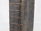 an old book sitting on top of a table next to a white wall