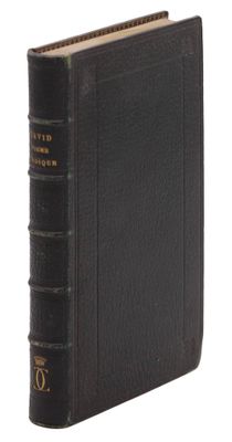 un vieux livre à la couverture noire posé sur une surface blanche