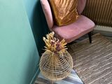 a pink chair in the corner of a room next to a radiator