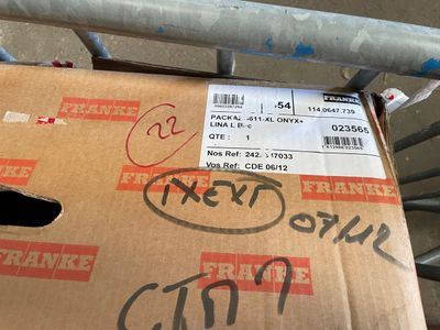 a cardboard box with a sticker on it sitting on a carton