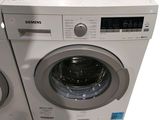 two washing machines sitting side by side next to each other