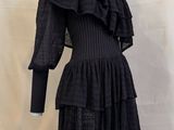 robe noire avec des volants au niveau de l'encolure du mannequin et des manches longues
