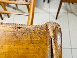 many wooden chairs in a room with white tile flooring