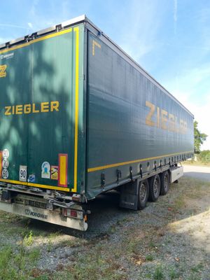 une semi-remorque verte garée sur le bord de la route