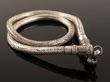 a close up of a silver snake on a black surface