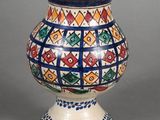 a vase with a design on it sitting on a table