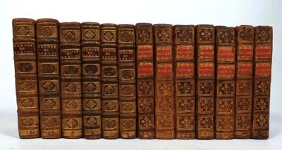 several old books are lined up in a row on a white surface