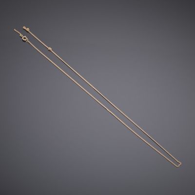 a pair of gold plated knitting needles on a grey background