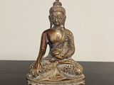 statue d'un Bouddha assis en position du lotus sur une table noire