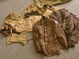 a pile of military clothing on the floor next to a bag