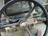 le volant et le tableau de bord d'un tracteur rouge