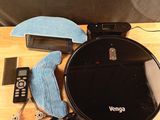 une table sur laquelle se trouvent une télécommande, un chiffon de nettoyage et d'autres objets