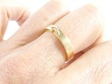 a person ' s hand with a gold ring on it