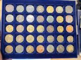 someone is holding a blue box with a lot of coins in it