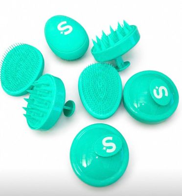 plusieurs brosses à cheveux et peignes verts posés sur une surface blanche