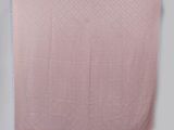 a pink blanket hanging on a wall next to a chair