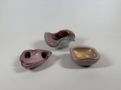 three different colored bowls sitting next to each other on a white surface