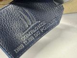 a black leather luggage tag hanging from the handle of a luggage bag