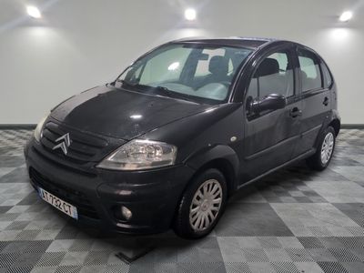 la photo d'une petite voiture noire garée sur un sol en damier