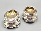 pair of silverplated sugar and butter dishes on a white surface