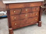 a small wooden chest of drawers with marble top