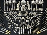 a lot of silver spoons and forks arranged in the shape of a star