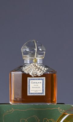 a bottle of perfume sitting on top of a green box