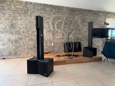 a room with a television, speakers, and a chair in it