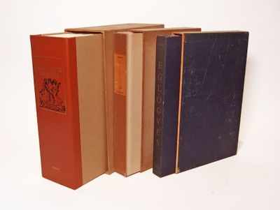 several books are lined up in a row on a white surface
