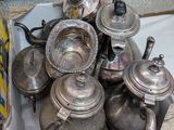 une pile de théières en argent posées sur une table