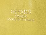 a close up of a yellow purse with a logo on it