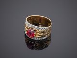 a close up of a gold ring with a ruby stone and diamonds