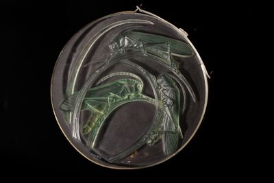 a close up of a metal object with a green design on it