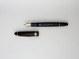 a black and gold fountain pen sitting on top of a white table