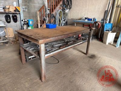 un établi au milieu d'un garage, sur lequel sont posés des outils