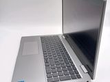 a silver laptop with a black keyboard on a white surface