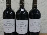trois bouteilles de vin posées sur une table en bois