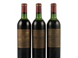 three bottles of wine sitting next to each other on a white surface
