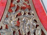 a silver metal clock with a red cloth covering it
