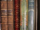 many old books on a shelf in a book case