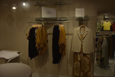 a lot of clothes hanging on a rack in a room