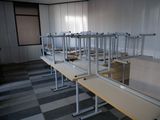 rows of empty desks in a room with a checkered floor