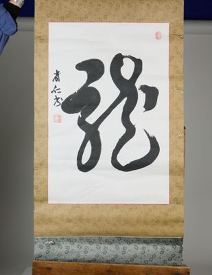 a man holding a large scroll with a painting on it