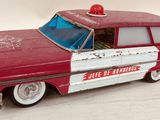 a red and white toy car that is on a white surface