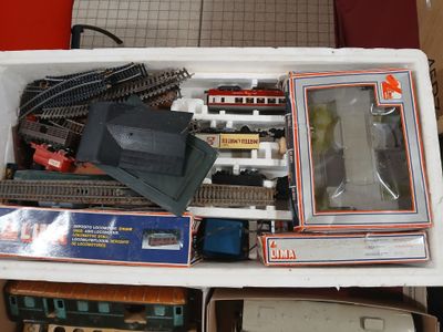 beaucoup de trains miniatures dans une boîte sur une table