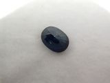 a blue sapphire stone sitting on top of a white surface