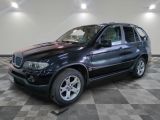 une photo d'un SUV bmw noir garé dans un garage