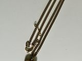 a necklace with a heart on it sitting on a table