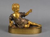 figurine en bronze représentant un garçon assis sur un socle