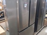 several stainless steel refrigerators are stacked on pallets in a warehouse